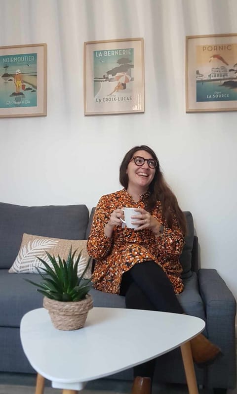 Aurélie Picard assise sur un canapé, une tasse à la main, souriante